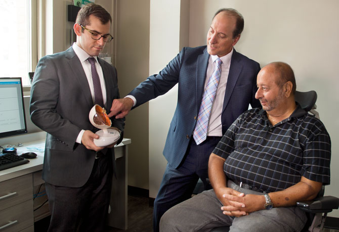 A photo showing Richard Kaplan, MD, a vitreoretinal surgery fellow at NYEE and Ronald Gentile, MD, with patient Joe Mauro explaining the new procedure for eye injections.