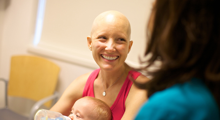 Nurse with cancer patient and her baby